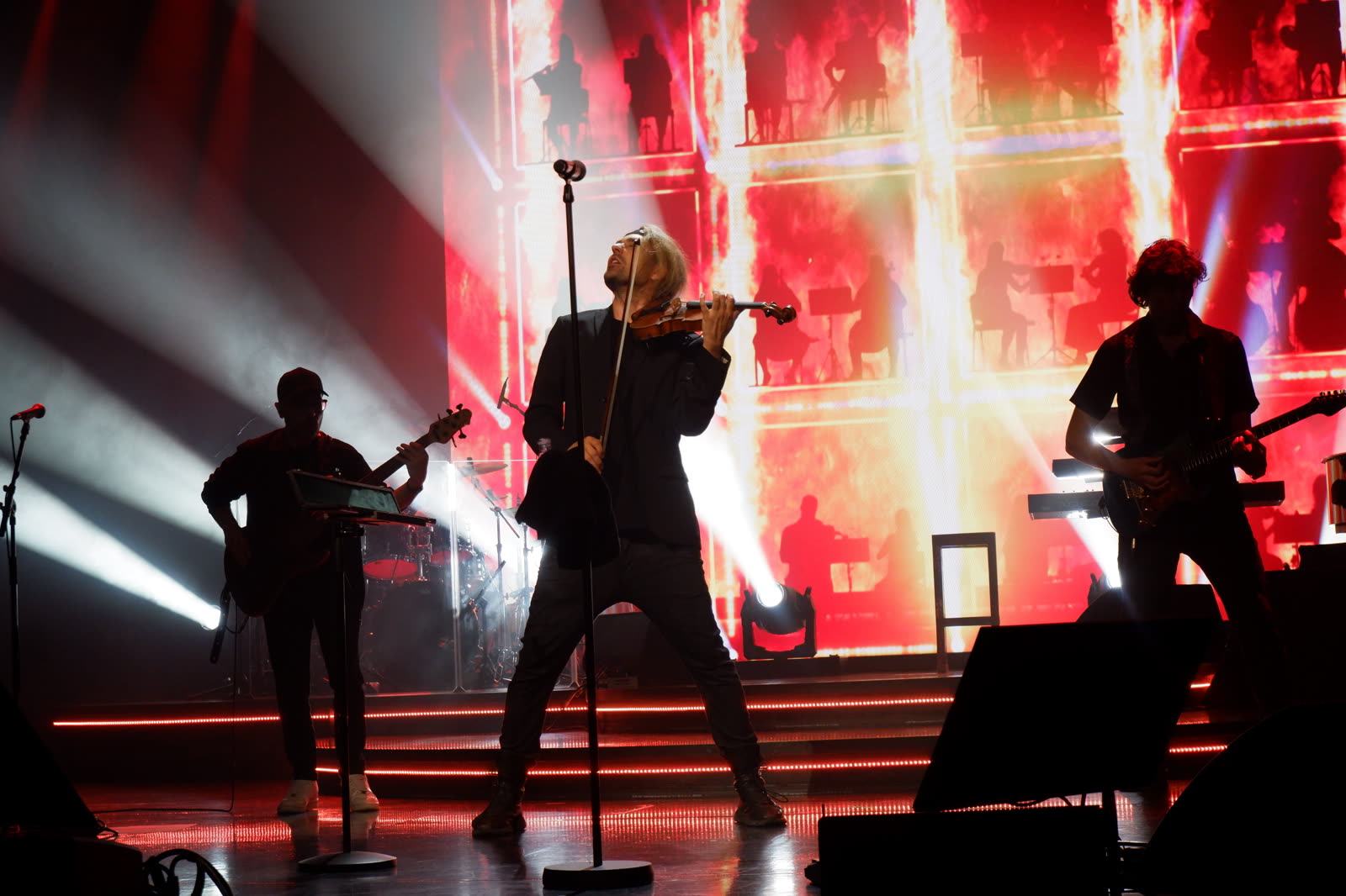 David Garrett at full power on stage with the band — red light explosion backdrop, Mein Schiff 1, David Garrett Cruise, April 2026, photographed by Ania Borkowska & Viola Turska