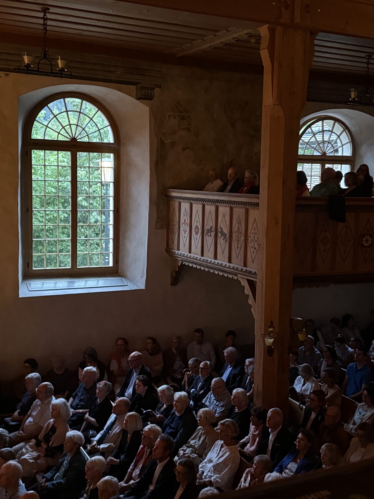 The interior of Kirche Saanen, wooden galleries and arched windows
